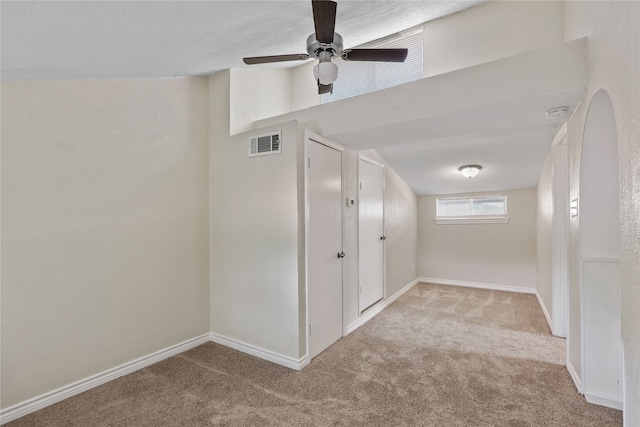 unfurnished room featuring light carpet and ceiling fan