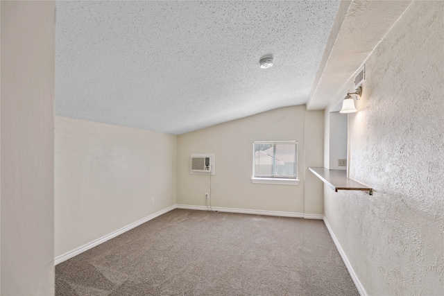 carpeted spare room with a textured ceiling and vaulted ceiling