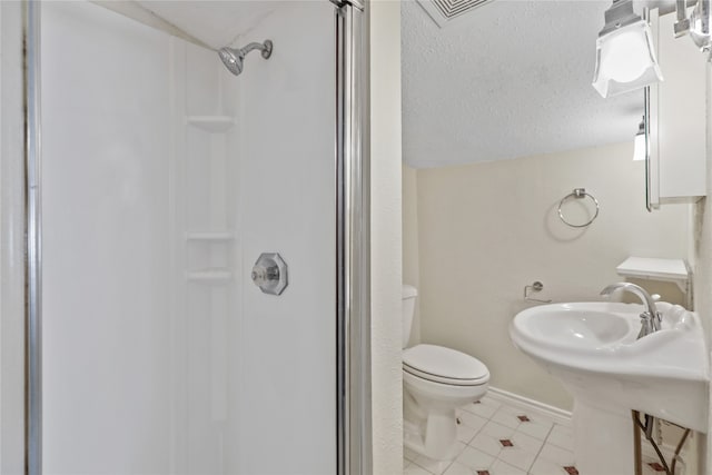 bathroom with sink, toilet, a shower, and a textured ceiling