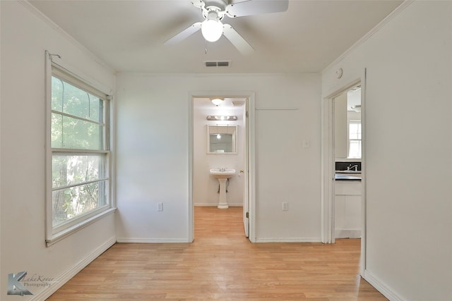 2909 Poplar St, Abilene, TX 79602 - unfurnished room with ornamental molding, light wood finished floors, ceiling fan, a sink, and baseboards