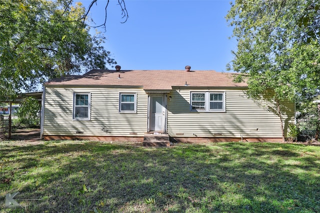 rear view of house featuring a lawn