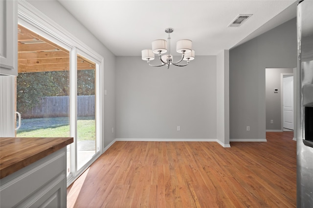 unfurnished dining area with a chandelier, light hardwood / wood-style flooring, and a wealth of natural light