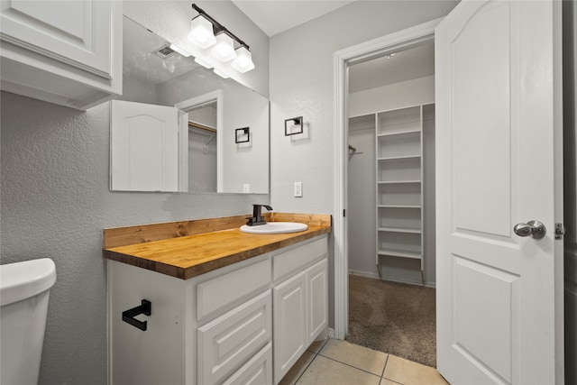 bathroom featuring tile patterned floors, vanity, and toilet