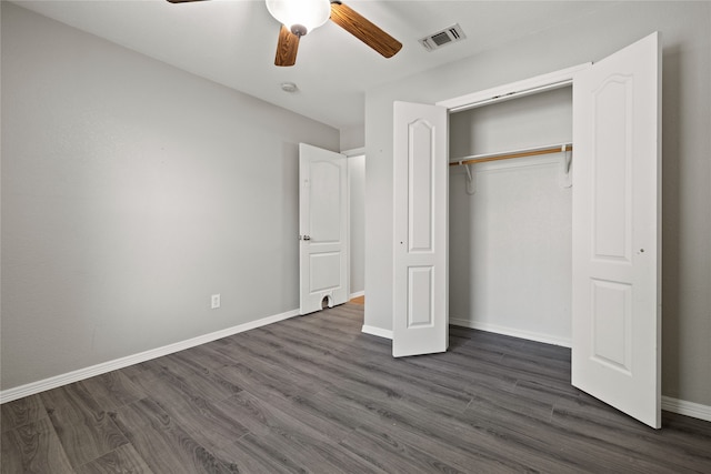 unfurnished bedroom featuring ceiling fan, dark hardwood / wood-style flooring, and a closet