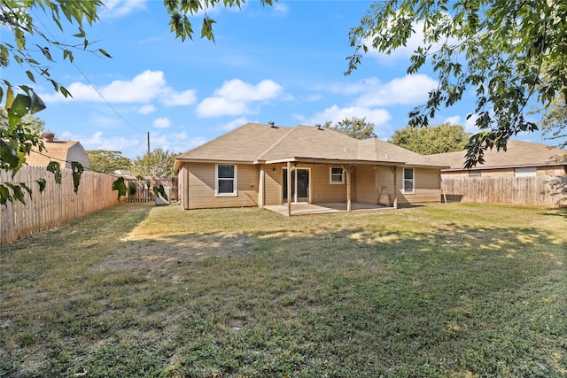 back of property with a patio area and a yard