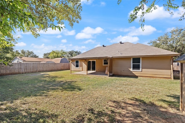 back of house with a lawn and a patio