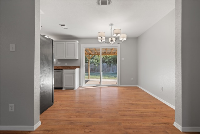 interior space with a chandelier and light hardwood / wood-style floors