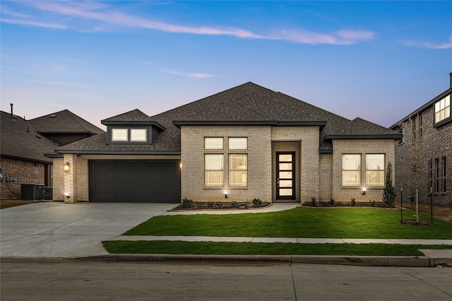 prairie-style house with a garage and a lawn