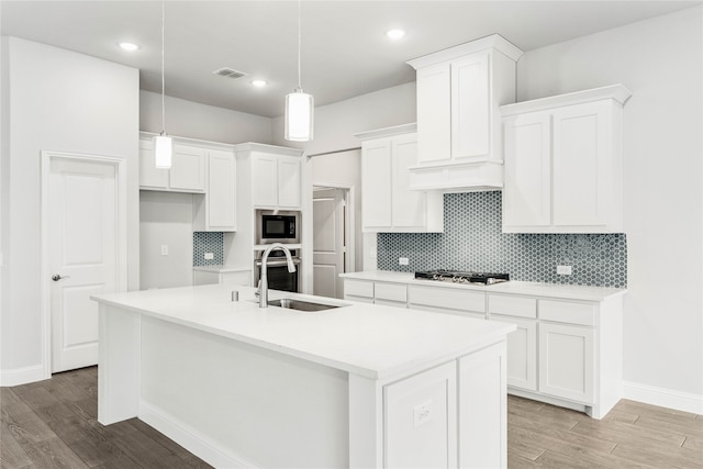 kitchen featuring a center island with sink, light hardwood / wood-style floors, and white cabinetry