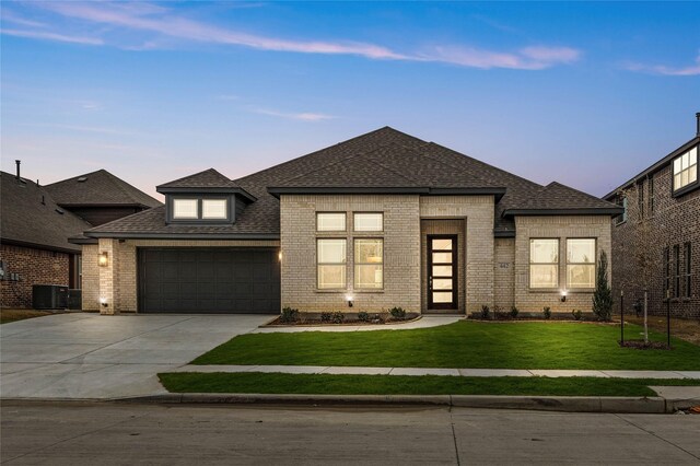 prairie-style home featuring a garage and a front lawn