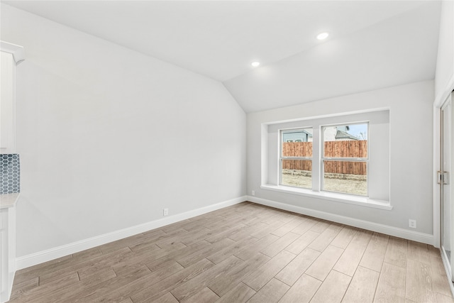 bonus room with light wood-type flooring and vaulted ceiling