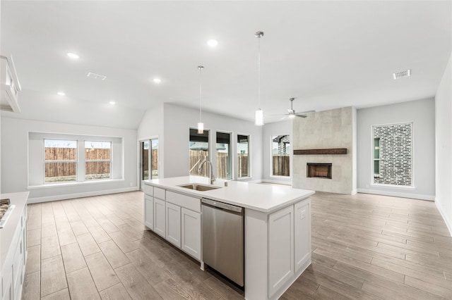 kitchen featuring white cabinetry, sink, ceiling fan, stainless steel dishwasher, and an island with sink