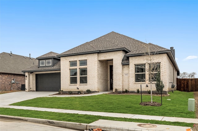 view of front facade featuring brick siding, driveway, a front yard, and fence