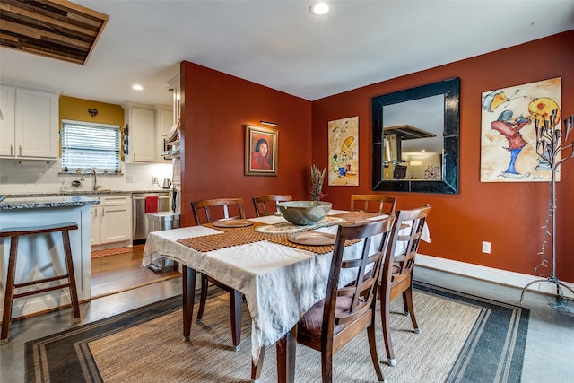 dining space with hardwood / wood-style floors and sink