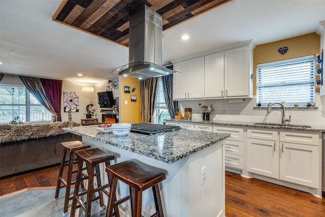 kitchen featuring island exhaust hood, light stone counters, white cabinets, and dark hardwood / wood-style floors