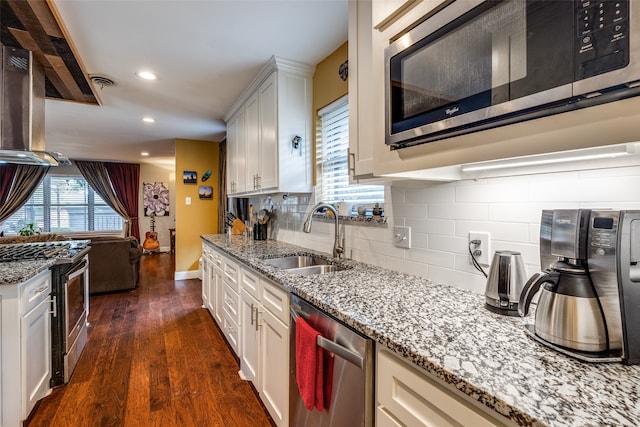 kitchen with decorative backsplash, appliances with stainless steel finishes, sink, white cabinets, and dark hardwood / wood-style floors