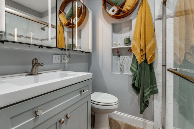 bathroom featuring vanity, hardwood / wood-style flooring, toilet, and a shower with door