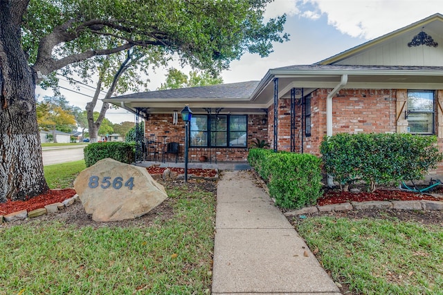 view of front of home featuring covered porch and a front lawn