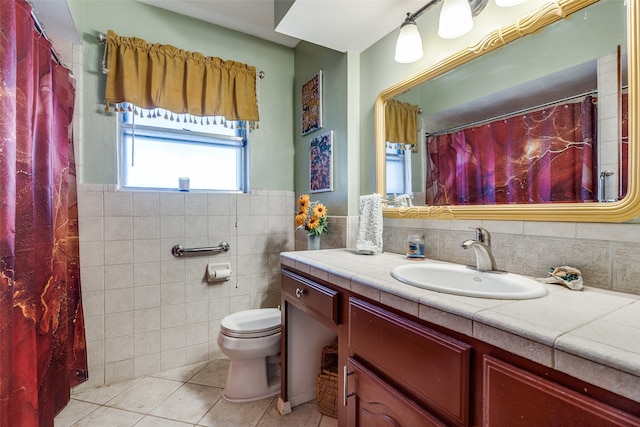 bathroom featuring tile patterned flooring, vanity, toilet, and tile walls