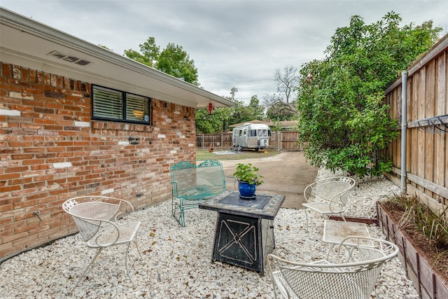 view of patio with a shed and a fire pit