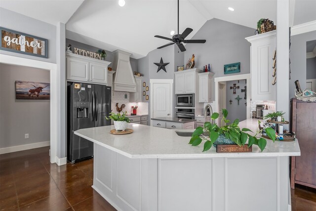 kitchen with ceiling fan, appliances with stainless steel finishes, a spacious island, and decorative backsplash