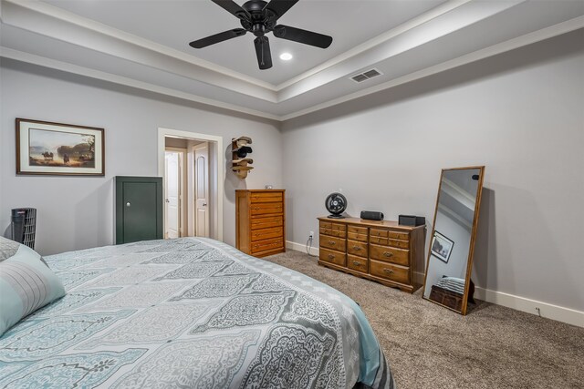 carpeted bedroom with recessed lighting, visible vents, baseboards, a raised ceiling, and crown molding