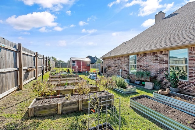 view of yard featuring a vegetable garden, an outdoor structure, and fence