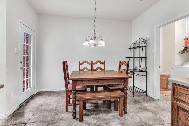 dining area with plenty of natural light, washer / dryer, and a chandelier