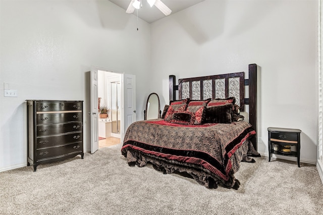 carpeted bedroom with connected bathroom, ceiling fan, and high vaulted ceiling