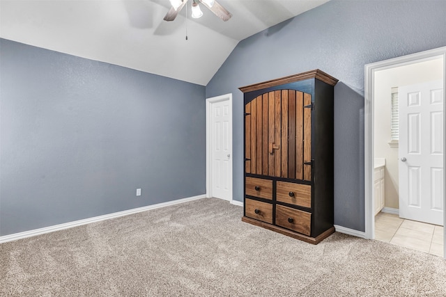 unfurnished bedroom featuring ceiling fan, lofted ceiling, light carpet, and connected bathroom