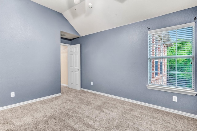 carpeted spare room with ceiling fan and lofted ceiling