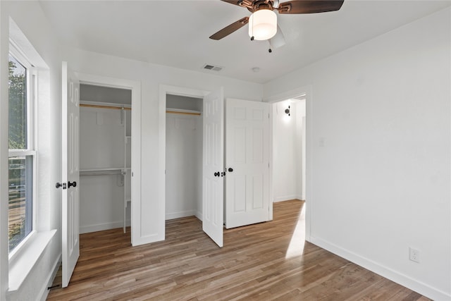 unfurnished bedroom with light wood-type flooring, multiple windows, and ceiling fan