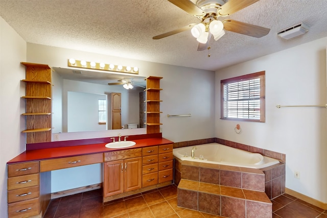 bathroom with tile patterned flooring, vanity, and a textured ceiling