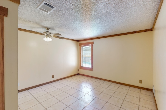 tiled empty room with ceiling fan, a textured ceiling, and ornamental molding