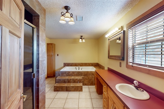 bathroom with separate shower and tub, tile patterned flooring, vanity, and a textured ceiling