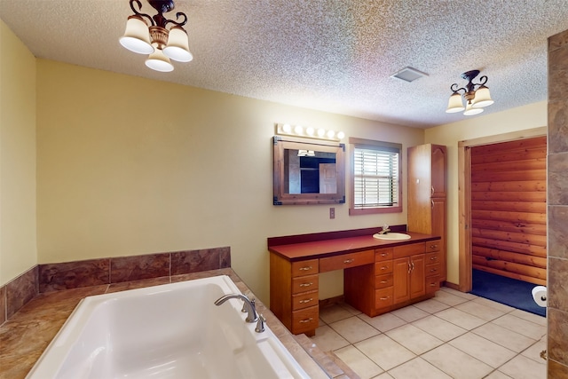 bathroom with tile patterned flooring, a bathtub, a textured ceiling, and vanity