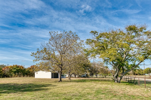 view of yard with an outbuilding, a rural view, and a garage