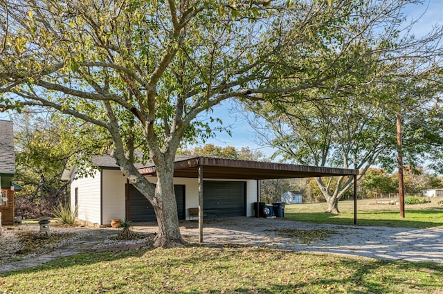 view of front of home with a front lawn, a garage, an outdoor structure, and a carport