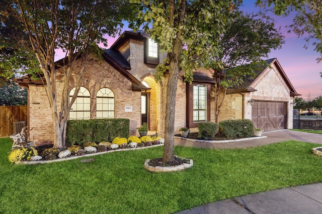 view of front facade with a garage and a lawn