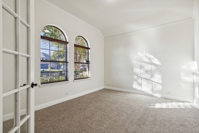 carpeted spare room with crown molding and vaulted ceiling