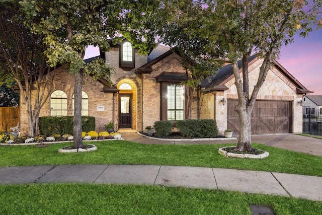 view of front of property with a yard and a garage