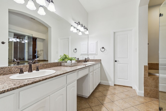 bathroom featuring tile patterned floors, tiled bath, and vanity