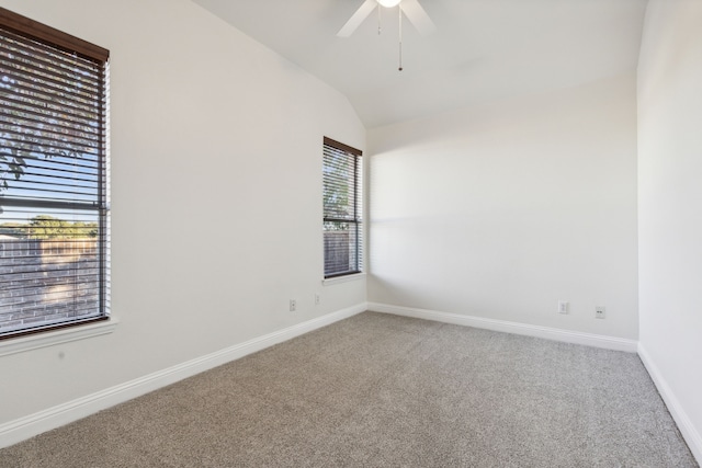 carpeted empty room featuring plenty of natural light, lofted ceiling, and ceiling fan