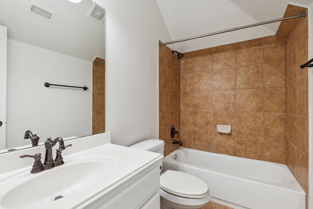 full bathroom featuring vanity, tiled shower / bath combo, and toilet