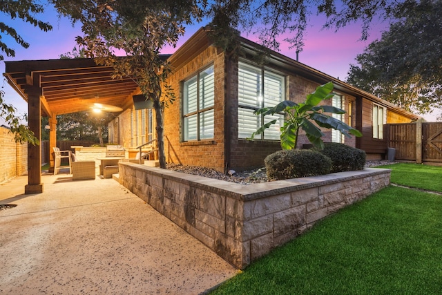 property exterior at dusk featuring a patio area