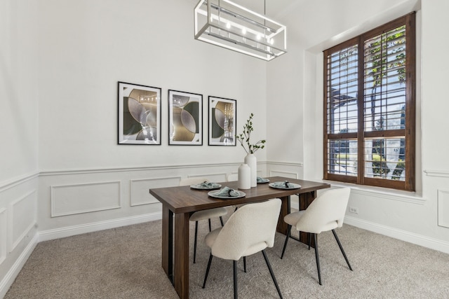 carpeted dining space with an inviting chandelier