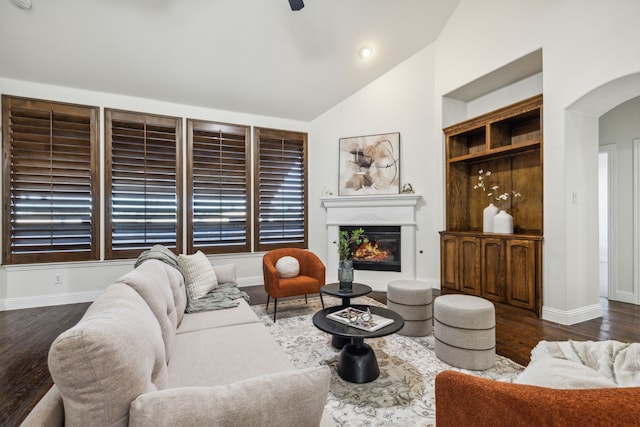 living room featuring built in shelves, dark hardwood / wood-style flooring, and vaulted ceiling