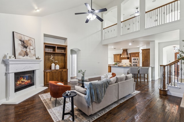 living room featuring ceiling fan, dark hardwood / wood-style flooring, and high vaulted ceiling