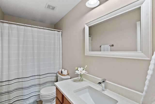 bathroom featuring vanity, a textured ceiling, and toilet