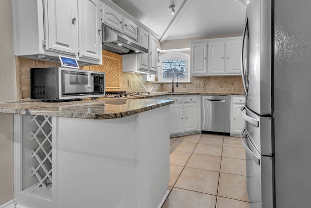 kitchen featuring light tile patterned flooring, sink, appliances with stainless steel finishes, dark stone counters, and white cabinets